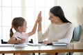 Joyful small daughter giving high five to mom. Royalty Free Stock Photo