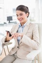 Joyful smart brown haired businesswoman using a mobile phone
