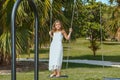 Joyful smiling little girl on a swing in tropical garden Royalty Free Stock Photo