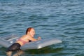 Joyful smiling teenage girl bathes with air mattress in the sea Royalty Free Stock Photo