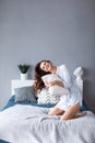 Joyful smiling woman holding a pillow on bed Royalty Free Stock Photo