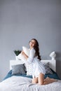 Joyful smiling woman holding a pillow on bed Royalty Free Stock Photo