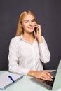 Joyful smiling young woman having talk by phone in office Royalty Free Stock Photo