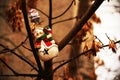 Joyful snowman toys hanging on tree with seeds