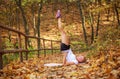 Joyful sports girl doing fitness exercises, warming up in forest park in autumn, healthy lifestyle, outdoor activities Royalty Free Stock Photo