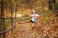 Joyful sports girl doing fitness exercises, warming up in forest park in autumn, healthy lifestyle, outdoor activities Royalty Free Stock Photo