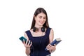 Joyful student girl with headset around her neck holding a book and her phone in hands, isolated on white background Royalty Free Stock Photo