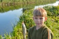 Joyful and surprised boy holds a fish hanging on a fishing rod Royalty Free Stock Photo