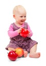 Joyful sweet baby in violet dress sits and apples