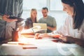 Joyful team brainstorming. Digital plan researching. Paperwork on the table, laptop and mobile phone Royalty Free Stock Photo