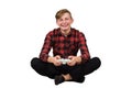 Joyful teen boy seated on the floor playing video games isolated on white background. Excited adolescent holding a joystick Royalty Free Stock Photo