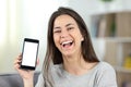 Joyful teen showing a mockup phone screen to camera