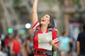 Joyful teen tourist holding a map on the street