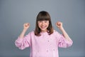 Joyful teenage girl raising her fists in celebration
