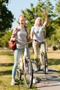 Joyful teenage girl riding a bicycle with her grandma