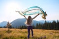 Joyful teenage girl with a waving scarf in her hands