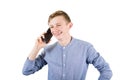 Joyful teenage guy talking with someone on his mobile phone isolated over white background. Adolescent boy speaking on smartphone Royalty Free Stock Photo