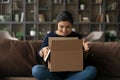 Joyful teenage indian female addressee looking inside big cardboard box