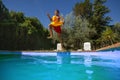 Joyful teenager jump with duck float in backyard, mid-air shot Royalty Free Stock Photo