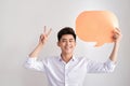 Joyful thinking man holding white empty speech balloon with space for text isolated on white background.