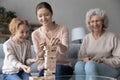 Joyful three different generations female family playing board game. Royalty Free Stock Photo