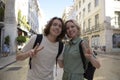 Joyful tourist couple making peace gesture