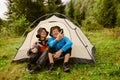 Joyful tourist couple taking selfie while sitting at camping tent in green forest Royalty Free Stock Photo