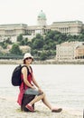 Joyful tourist woman posing with Buda castle on the Danube river