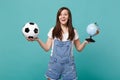 Joyful woman football fan cheer up support favorite team with soccer ball, Earth world globe isolated on blue turquoise