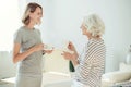 Joyful woman and her senior mother drinking coffee Royalty Free Stock Photo