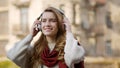 Joyful woman listening music headphones on street. Happy girl using earphones. Royalty Free Stock Photo