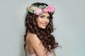 Joyful woman with make-up, perfect white toothy smile and spring or summer season rose flower wreath on her long healthy shiny Royalty Free Stock Photo