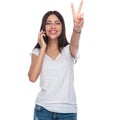 Joyful woman speaking on the phone and making victory sign Royalty Free Stock Photo