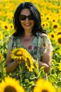 Joyful woman with sunglasses posing with sunflowers Royalty Free Stock Photo