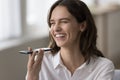 Joyful woman talking on smartphone using speakerphone, close up