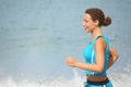 Joyful woman wearing sporty clothers is running.