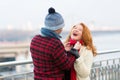 Joyful woman loves date. Guy make funny woman in red scarf. Rouge woman laughing in city