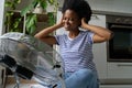 Joyful young African woman using electric floor fan at home, cooling herself, enjoying fresh air Royalty Free Stock Photo
