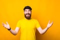 Joyful young bearded man making welcome gesture over yellow background, nice to meet you Royalty Free Stock Photo