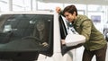 Joyful young Caucasian couple checking new luxury car before purchase at dealership automobile salon, banner design Royalty Free Stock Photo