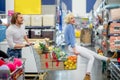 Young happy man pushing shopping trolley with his girfriend in mall Royalty Free Stock Photo