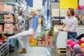 Young happy man pushing shopping trolley with his girfriend in mall Royalty Free Stock Photo