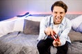 Joyful young Caucasian male playing game at home on console station. Smiling millennial man gamer having fun enjoy world Royalty Free Stock Photo