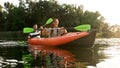 Joyful young couple having fun while kayaking in a river surrounded by the beautiful nature on a summer day Royalty Free Stock Photo