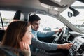 Joyful young couple sitting in a car dealership inside their new car Royalty Free Stock Photo