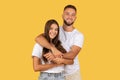 A joyful young couple in white t-shirts and denim hugging and smiling broadly Royalty Free Stock Photo