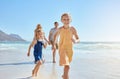 Joyful young family with two children running on the beach and enjoying a fun summer vacation. Two energetic little Royalty Free Stock Photo