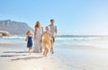 Joyful young family with two children running on the beach and enjoying summer vacation. Two energetic little girls Royalty Free Stock Photo