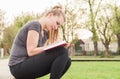 Joyful young female in spring park writing in her diary Royalty Free Stock Photo