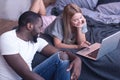 Joyful young international couple enjoying modern technologies at home Royalty Free Stock Photo